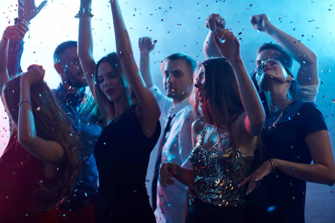 Ecstatic people dancing in night club