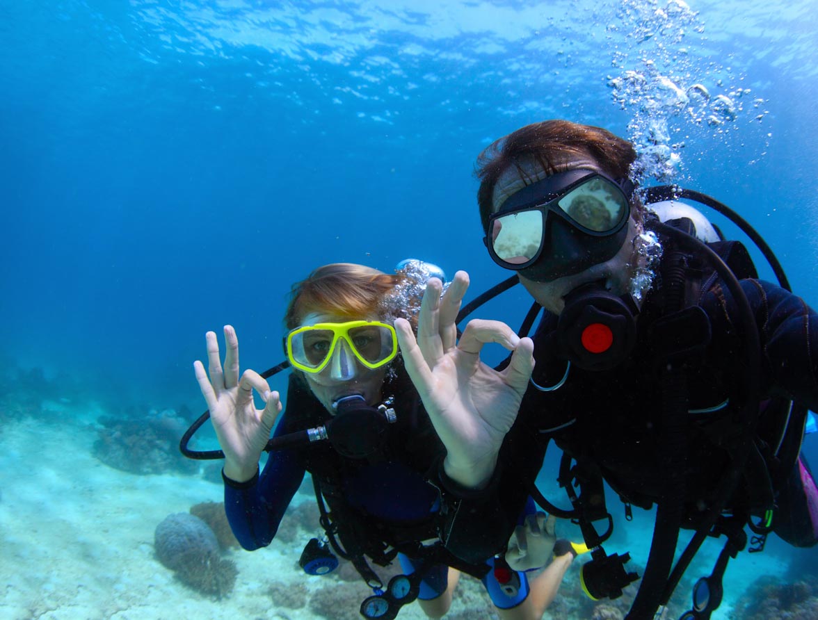 Scuba divers underwater showing ok signal