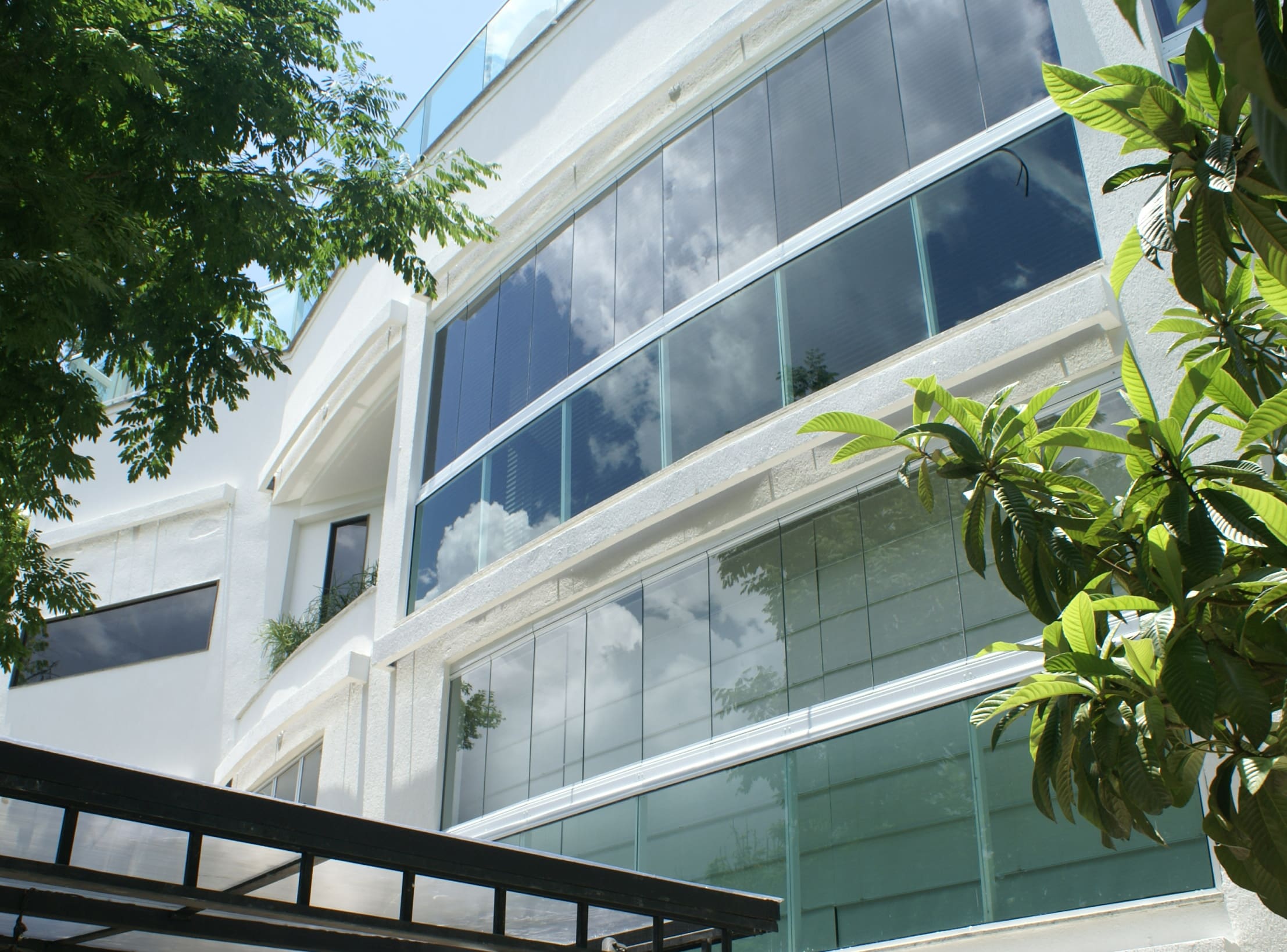A front view of the Rio Holiday Boutique Hotel showing modern design and curved glass windows.